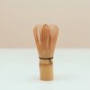 A close-up of a traditional bamboo tea whisk against a simple backdrop, perfect for ceremonies.